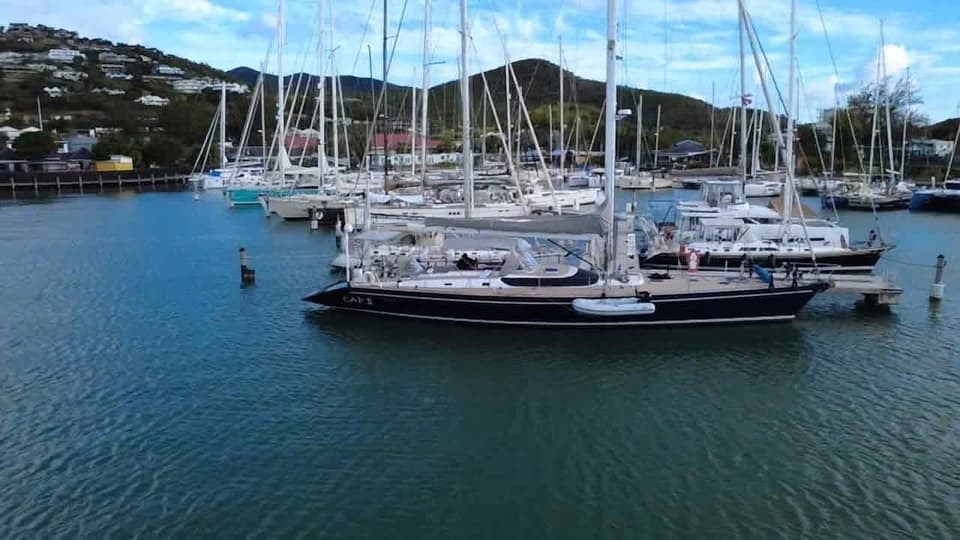 Aerial view of Cap II among other yachts in a marina.